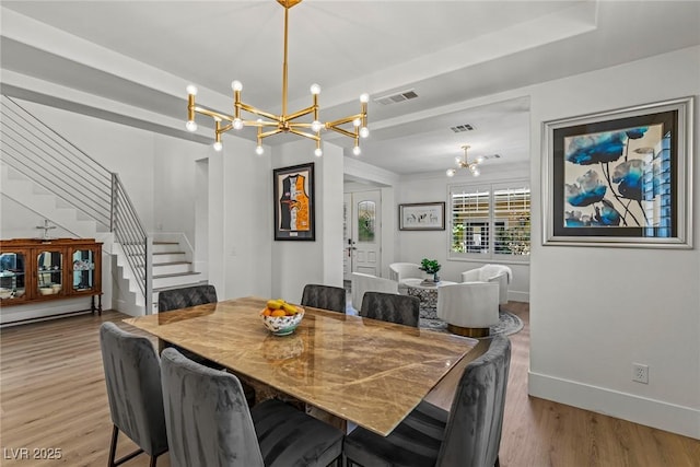 712 Proud Eagle Ln, Las Vegas, NV 89144 - dining space with a chandelier, stairway, and light wood-style flooring
