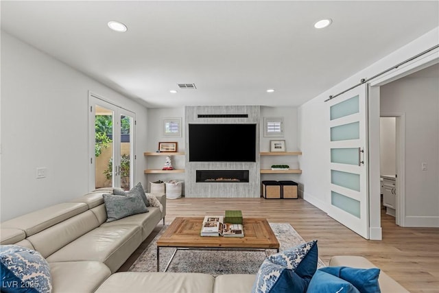 712 Proud Eagle Ln, Las Vegas, NV 89144 - living room featuring wood finished floors, a barn door, recessed lighting, and a large fireplace