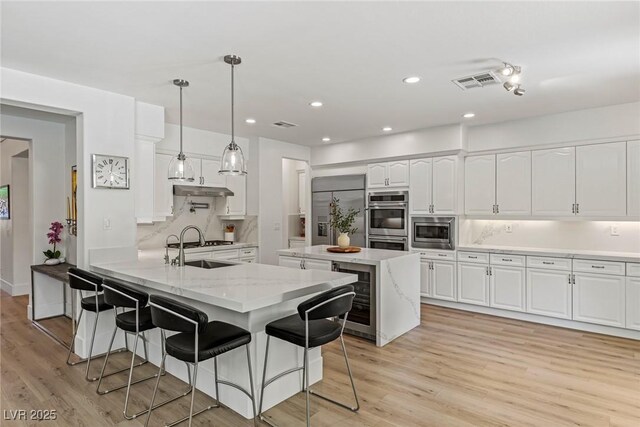 712 Proud Eagle Ln, Las Vegas, NV 89144 - kitchen with built in appliances, wine cooler, a peninsula, white cabinets, and recessed lighting