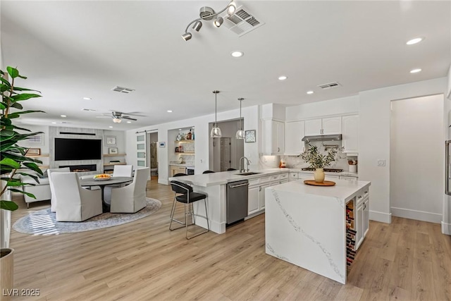 712 Proud Eagle Ln, Las Vegas, NV 89144 - kitchen featuring stainless steel dishwasher, a peninsula, light countertops, open floor plan, and white cabinets
