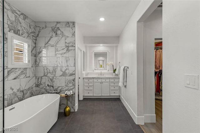712 Proud Eagle Ln, Las Vegas, NV 89144 - full bathroom featuring a freestanding tub, vanity, a walk in closet, and tile walls