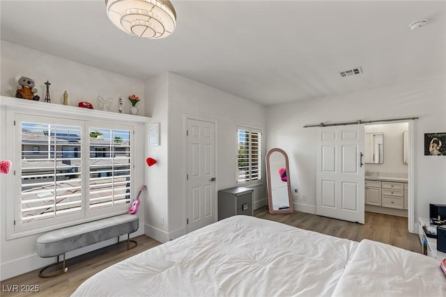 712 Proud Eagle Ln, Las Vegas, NV 89144 - bedroom with multiple windows, wood finished floors, and connected bathroom