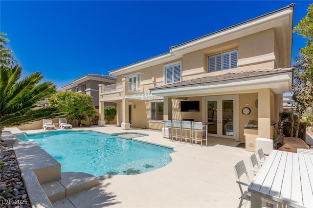 712 Proud Eagle Ln, Las Vegas, NV 89144 - rear view of house featuring a patio area, an outdoor pool, a balcony, stucco siding, and french doors