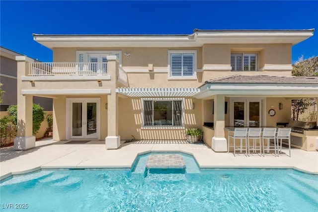 712 Proud Eagle Ln, Las Vegas, NV 89144 - back of property with french doors, a balcony, stucco siding, and an outdoor pool