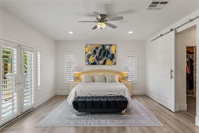 712 Proud Eagle Ln, Las Vegas, NV 89144 - bedroom featuring a barn door, light wood-style flooring, recessed lighting, ceiling fan, and a walk in closet