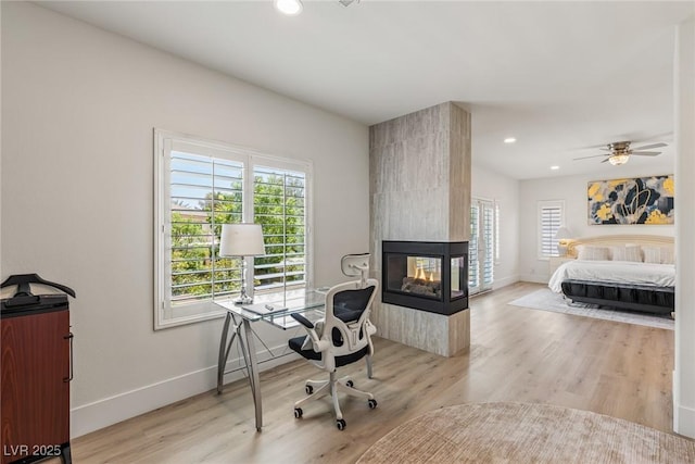 712 Proud Eagle Ln, Las Vegas, NV 89144 - office with wood finished floors, a multi sided fireplace, recessed lighting, and a ceiling fan