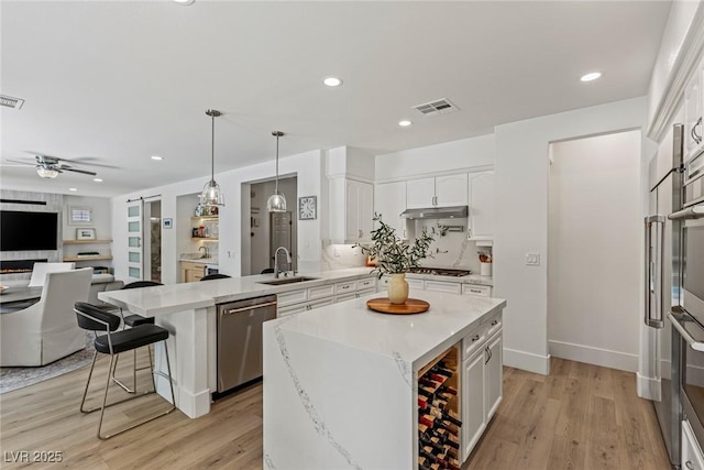 712 Proud Eagle Ln, Las Vegas, NV 89144 - kitchen featuring appliances with stainless steel finishes, a peninsula, open floor plan, white cabinetry, and ceiling fan