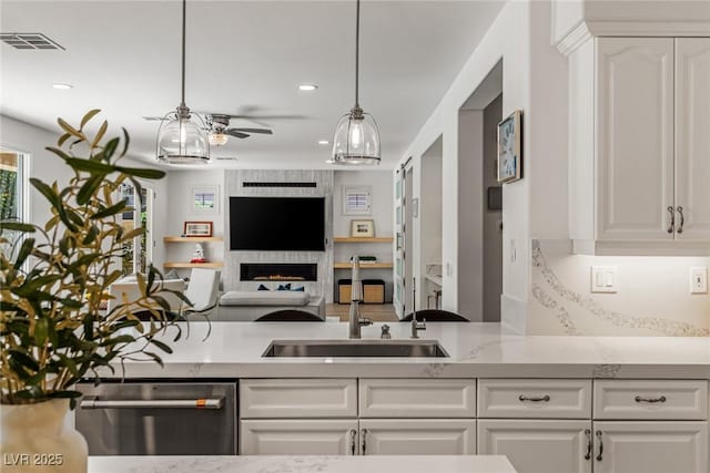 712 Proud Eagle Ln, Las Vegas, NV 89144 - kitchen with dishwasher, a ceiling fan, open floor plan, white cabinets, and hanging light fixtures