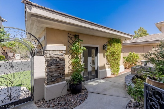 712 Proud Eagle Ln, Las Vegas, NV 89144 - view of exterior entry featuring french doors, a gate, stone siding, and stucco siding