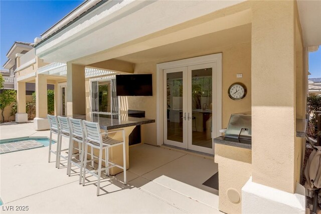 712 Proud Eagle Ln, Las Vegas, NV 89144 - view of patio / terrace featuring french doors, an outdoor kitchen, an outdoor bar, and an outdoor pool