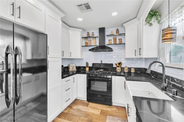 6536 Pleasant Plains Way, Las Vegas, NV 89108 - kitchen featuring freestanding refrigerator, wall chimney range hood, black range with gas cooktop, open shelves, and white cabinets