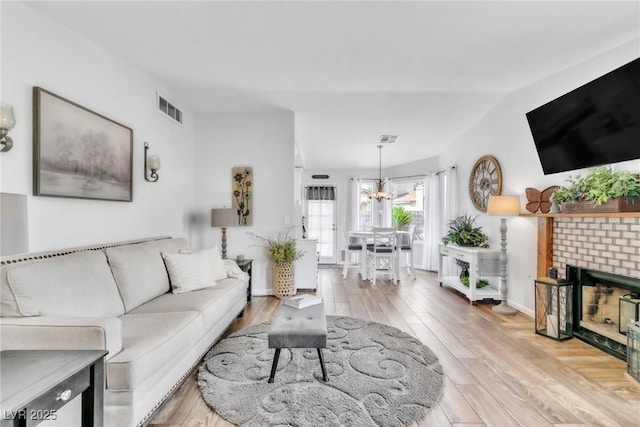 6536 Pleasant Plains Way, Las Vegas, NV 89108 - living room featuring a chandelier, wood finished floors, and a fireplace