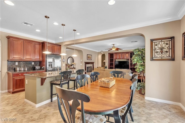 4408 Oasis Plains Ave, North Las Vegas, NV 89085 - dining area with arched walkways, a ceiling fan, crown molding, light tile patterned floors, and recessed lighting