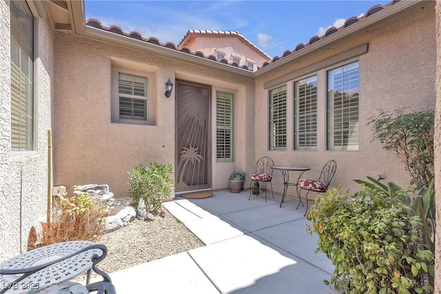 4408 Oasis Plains Ave, North Las Vegas, NV 89085 - view of exterior entry with a patio, stucco siding, and a tiled roof