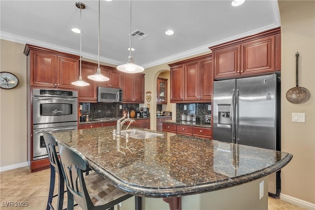 4408 Oasis Plains Ave, North Las Vegas, NV 89085 - kitchen with stainless steel appliances, backsplash, arched walkways, crown molding, and decorative light fixtures
