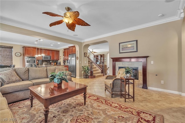 4408 Oasis Plains Ave, North Las Vegas, NV 89085 - living room with a ceiling fan, arched walkways, stairway, a premium fireplace, and ornamental molding