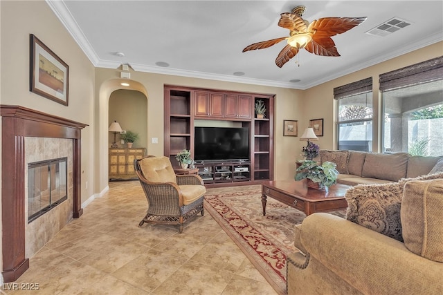 4408 Oasis Plains Ave, North Las Vegas, NV 89085 - living area featuring ceiling fan, crown molding, a tiled fireplace, arched walkways, and light tile patterned flooring
