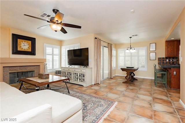 8875 Tidal Bay Dr, Las Vegas, NV 89117 - living area featuring plenty of natural light, a fireplace, ceiling fan, and a chandelier