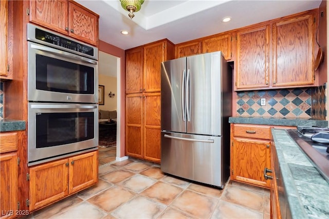 8875 Tidal Bay Dr, Las Vegas, NV 89117 - kitchen with stainless steel appliances, tasteful backsplash, brown cabinetry, and recessed lighting