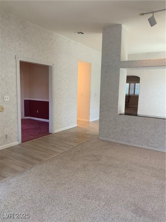 6704 Lost River Ct, Las Vegas, NV 89108 - carpeted empty room featuring track lighting and wood finished floors