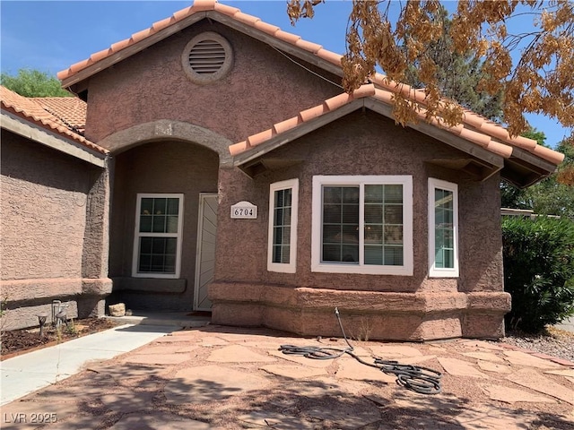 6704 Lost River Ct, Las Vegas, NV 89108 - entrance to property with a tiled roof and stucco siding