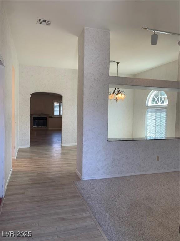 6704 Lost River Ct, Las Vegas, NV 89108 - corridor with wood finished floors, arched walkways, and a chandelier