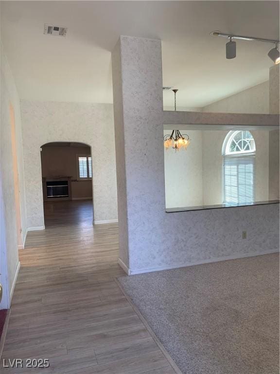 6704 Lost River Ct, Las Vegas, NV 89108 - hall with wood finished floors, a chandelier, vaulted ceiling, and arched walkways