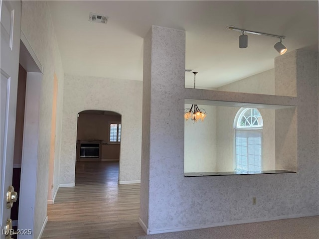 6704 Lost River Ct, Las Vegas, NV 89108 - hallway featuring arched walkways, plenty of natural light, wood finished floors, and track lighting