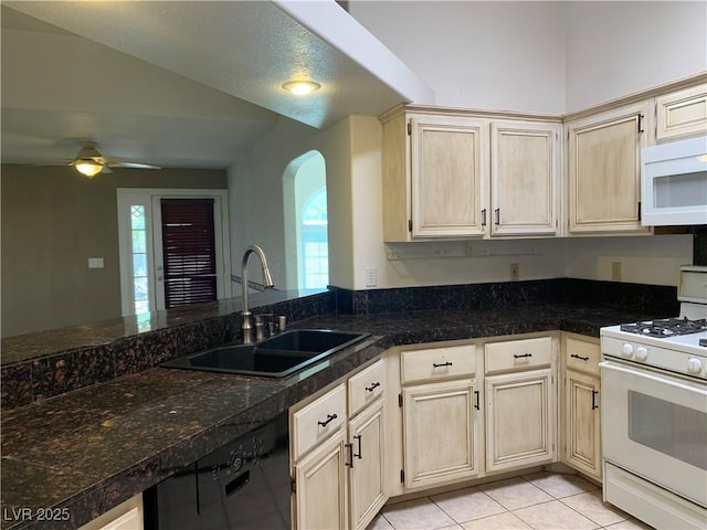 6704 Lost River Ct, Las Vegas, NV 89108 - kitchen with white appliances, ceiling fan, arched walkways, lofted ceiling, and light tile patterned floors