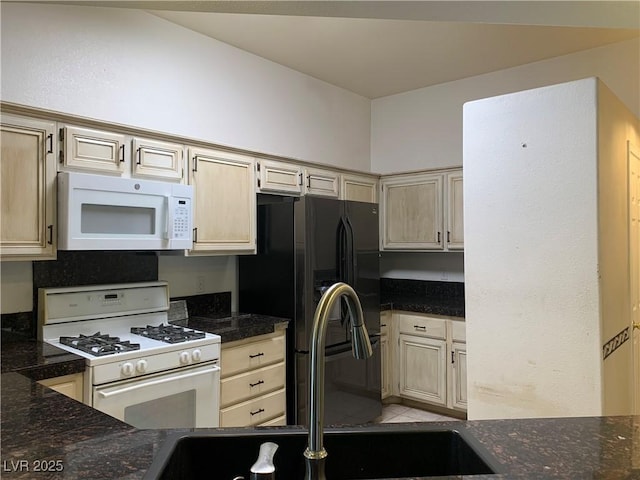 6704 Lost River Ct, Las Vegas, NV 89108 - kitchen with white appliances, light tile patterned floors, and dark stone counters