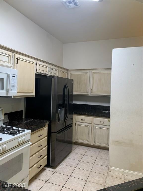 6704 Lost River Ct, Las Vegas, NV 89108 - kitchen featuring white appliances, light tile patterned floors, and dark countertops