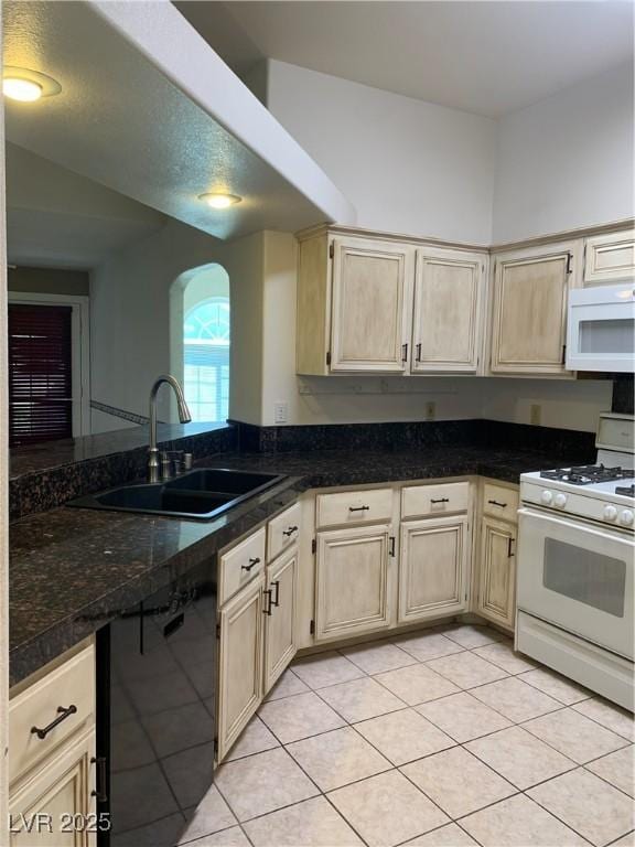 6704 Lost River Ct, Las Vegas, NV 89108 - kitchen with white appliances, light tile patterned floors, arched walkways, a peninsula, and dark countertops