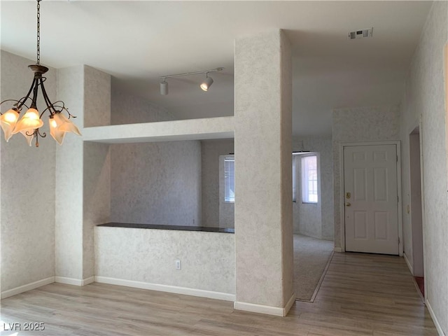 6704 Lost River Ct, Las Vegas, NV 89108 - unfurnished dining area featuring wood finished floors, track lighting, and a chandelier
