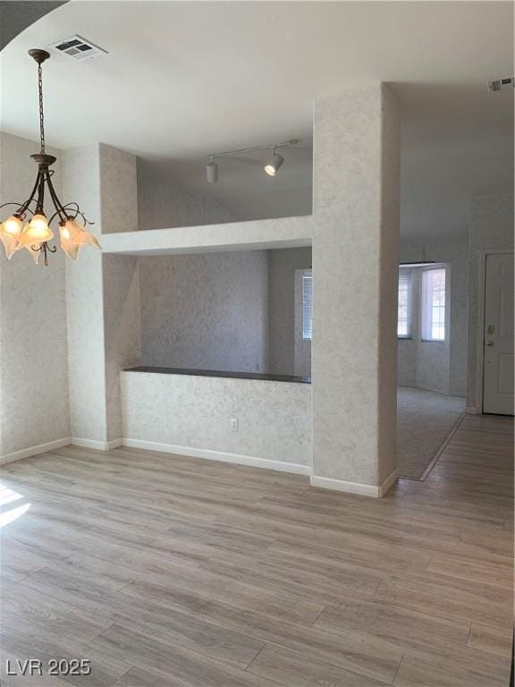 6704 Lost River Ct, Las Vegas, NV 89108 - unfurnished room featuring wood finished floors, rail lighting, and a textured wall