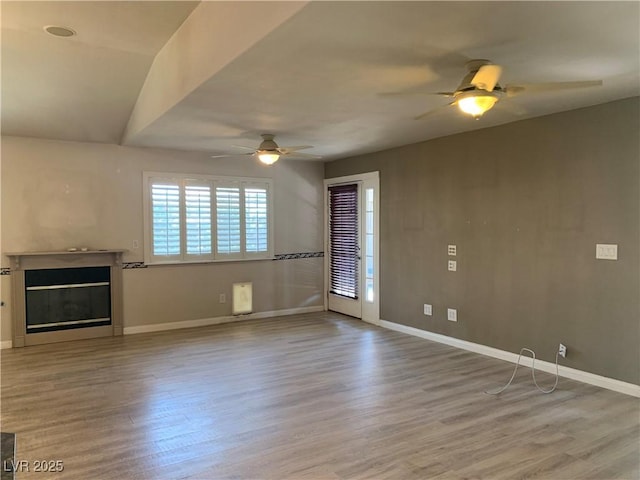 6704 Lost River Ct, Las Vegas, NV 89108 - unfurnished living room with ceiling fan, wood finished floors, and a glass covered fireplace