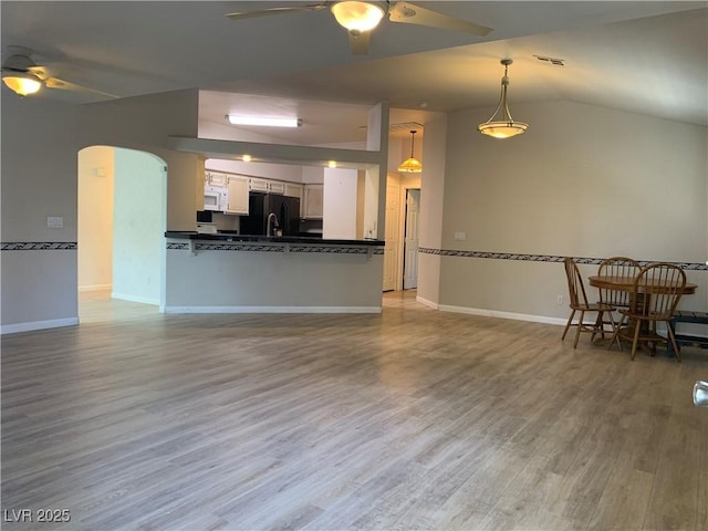 6704 Lost River Ct, Las Vegas, NV 89108 - living area featuring a ceiling fan, arched walkways, wood finished floors, and lofted ceiling