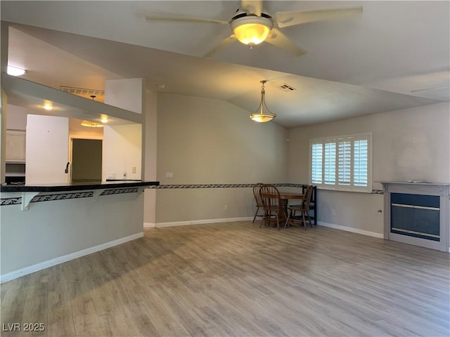 6704 Lost River Ct, Las Vegas, NV 89108 - unfurnished living room featuring wood finished floors, a ceiling fan, a fireplace, and lofted ceiling