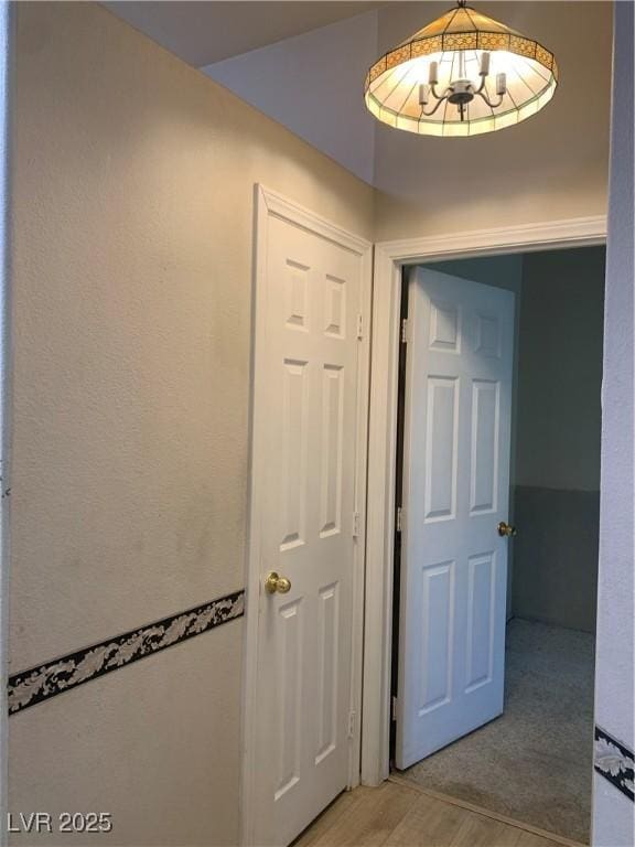6704 Lost River Ct, Las Vegas, NV 89108 - hallway with light wood-type flooring and a chandelier