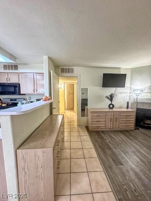 3101 Casey Dr Unit 204, Las Vegas, NV 89120 - kitchen with black microwave, electric stove, a textured ceiling, and light tile patterned floors