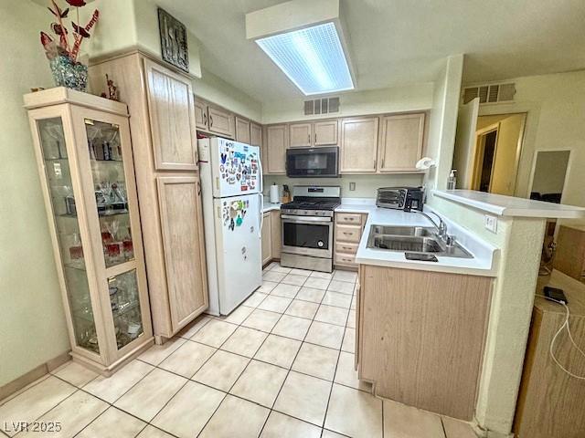 3101 Casey Dr Unit 204, Las Vegas, NV 89120 - kitchen with freestanding refrigerator, stainless steel gas range, black microwave, light countertops, and light tile patterned floors
