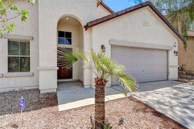 3609 Blue Pimpernel Ave, North Las Vegas, NV 89081 - doorway to property featuring stucco siding, an attached garage, and driveway