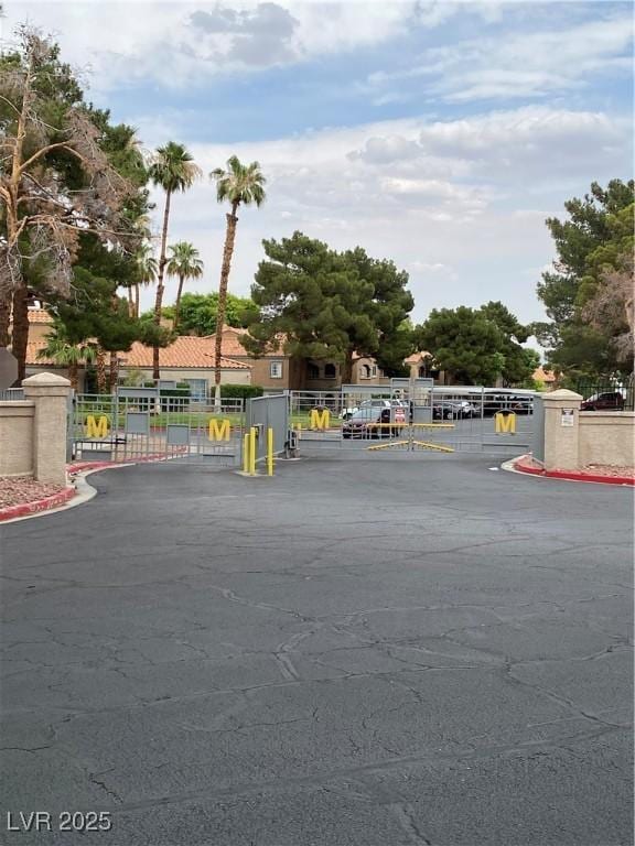 220 Mission Catalina Ln Unit 203, Las Vegas, NV 89107 - view of asphalt street featuring a gate, a gated entry, and curbs