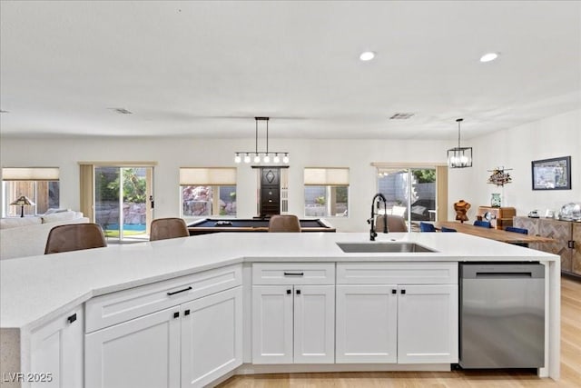 9612 Glengarry Dr, Las Vegas, NV 89129 - kitchen with stainless steel dishwasher, open floor plan, light countertops, white cabinetry, and plenty of natural light