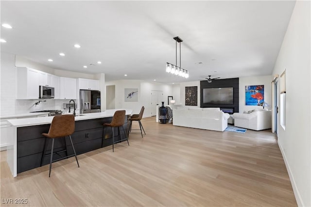 9612 Glengarry Dr, Las Vegas, NV 89129 - kitchen with stainless steel appliances, light wood-type flooring, recessed lighting, white cabinets, and a ceiling fan