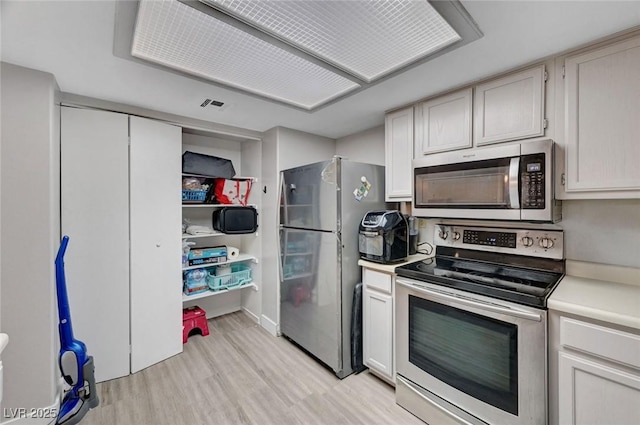9070 Spring Mountain Rd Unit 114, Las Vegas, NV 89117 - kitchen featuring appliances with stainless steel finishes, light wood-style flooring, and light countertops