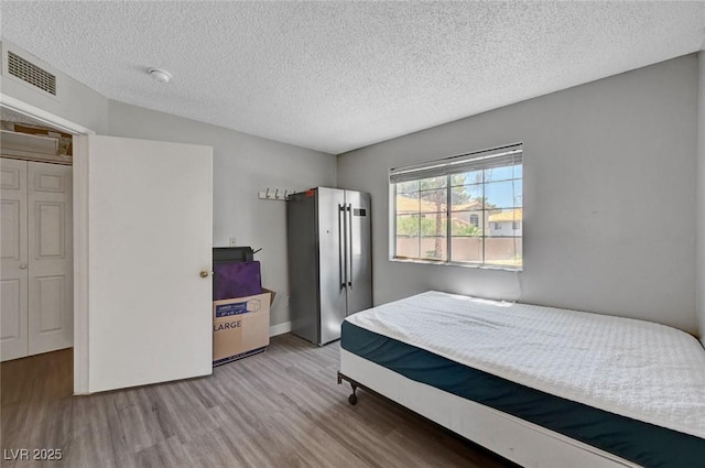 9070 Spring Mountain Rd Unit 114, Las Vegas, NV 89117 - bedroom with wood finished floors and a textured ceiling