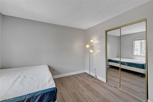 9070 Spring Mountain Rd Unit 114, Las Vegas, NV 89117 - bedroom featuring wood finished floors, a textured ceiling, and a closet