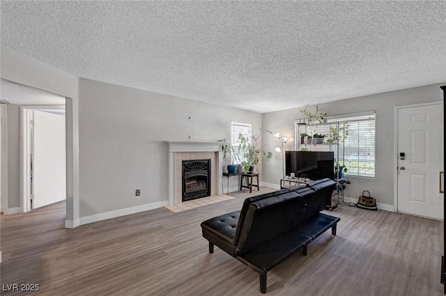 9070 Spring Mountain Rd Unit 114, Las Vegas, NV 89117 - living area featuring wood finished floors, healthy amount of natural light, a textured ceiling, and a tile fireplace