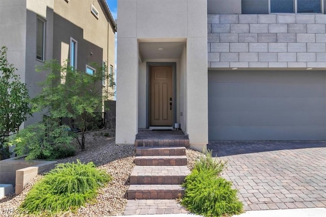 11695 Gentle Birdsong Ave, Las Vegas, NV 89138 - property entrance featuring stucco siding, decorative driveway, and a garage