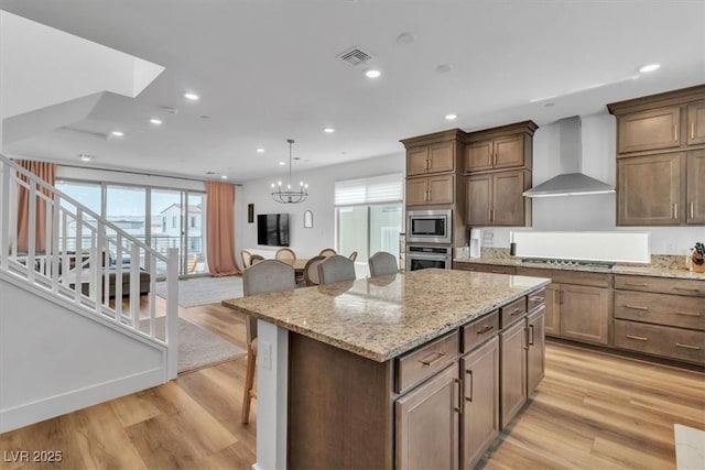 11695 Gentle Birdsong Ave, Las Vegas, NV 89138 - kitchen featuring wall chimney range hood, appliances with stainless steel finishes, a kitchen island, a kitchen breakfast bar, and recessed lighting